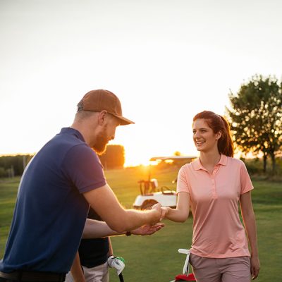 Shot of two couples playing a round of golf together on a sunny day.